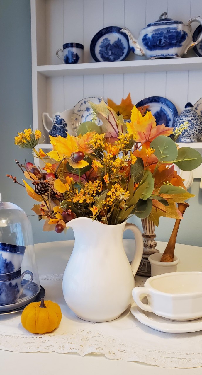 Fall flowers put inside a white pitcher makes the colors pop.