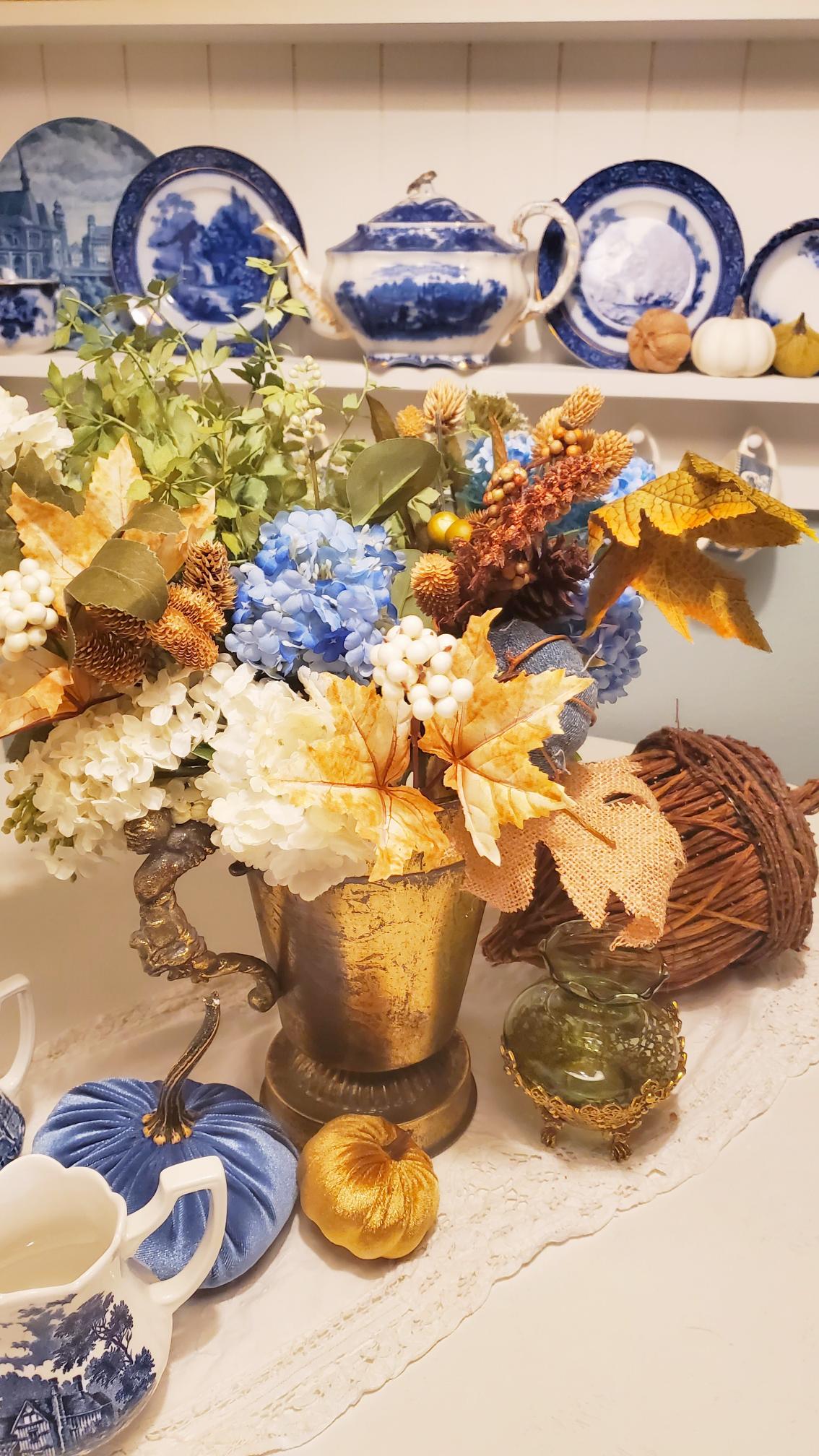 Bouquet of fall flowers on our breakfast nook table. Flow blue dishes on shelf.